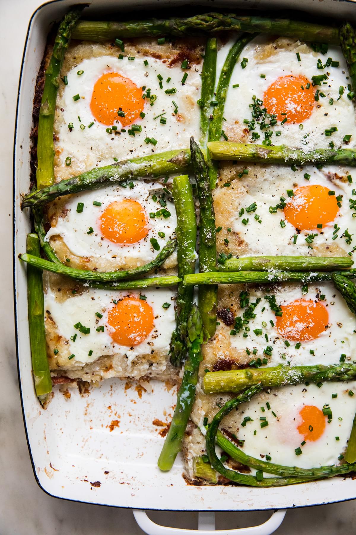 homemade potato rösti with eggs and asparagus in a baking dish