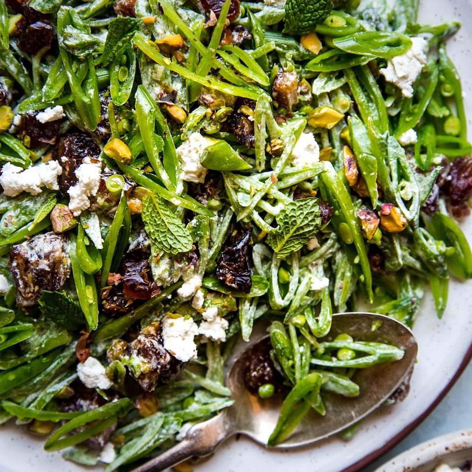 Shaved Snap Pea Salad with Goat Cheese and Dates in a bowl