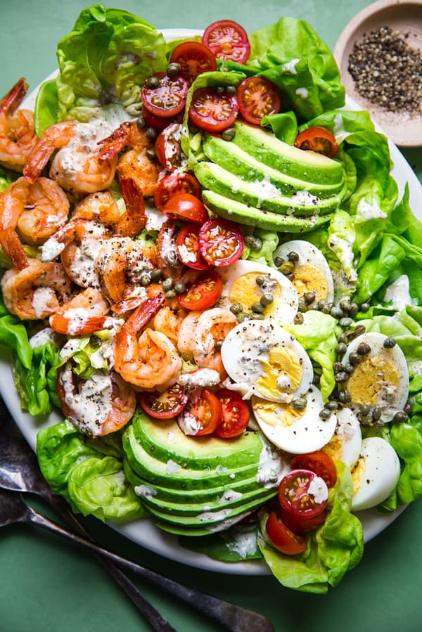 homemade shrimp louie salad with avocado, hard boiled eggs, tomatoes and capers with a tangy dressing