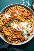 homemade simple ragù in a bowl topped with parmesan cheese