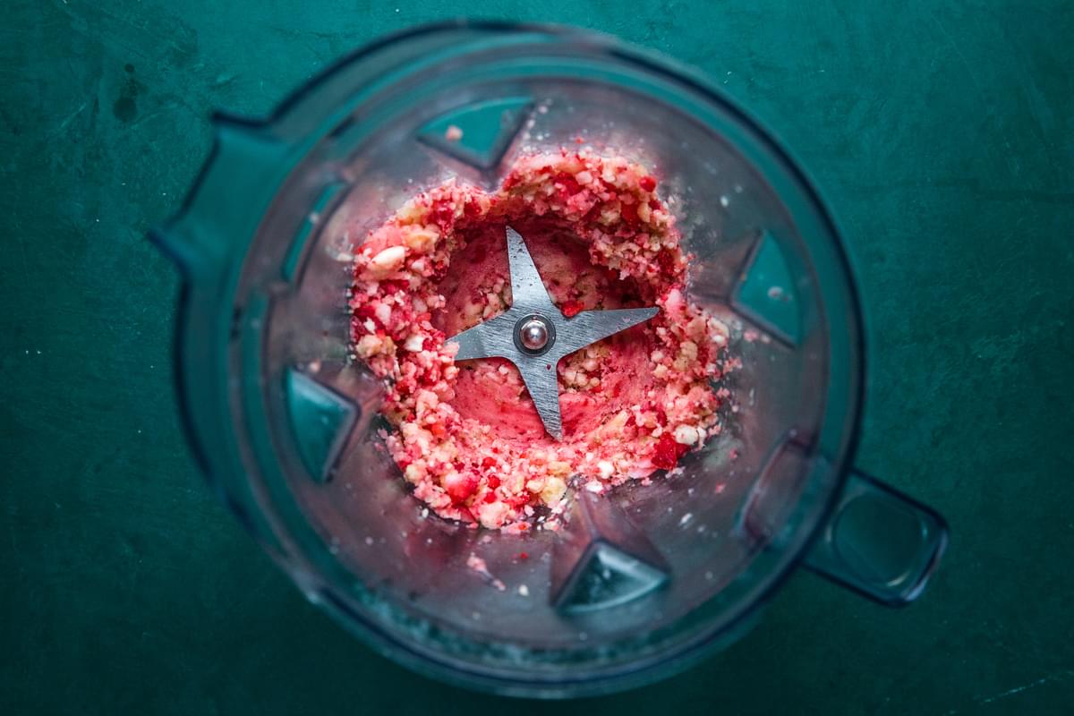 frozen pieces of strawberries and bananas blended in a blender