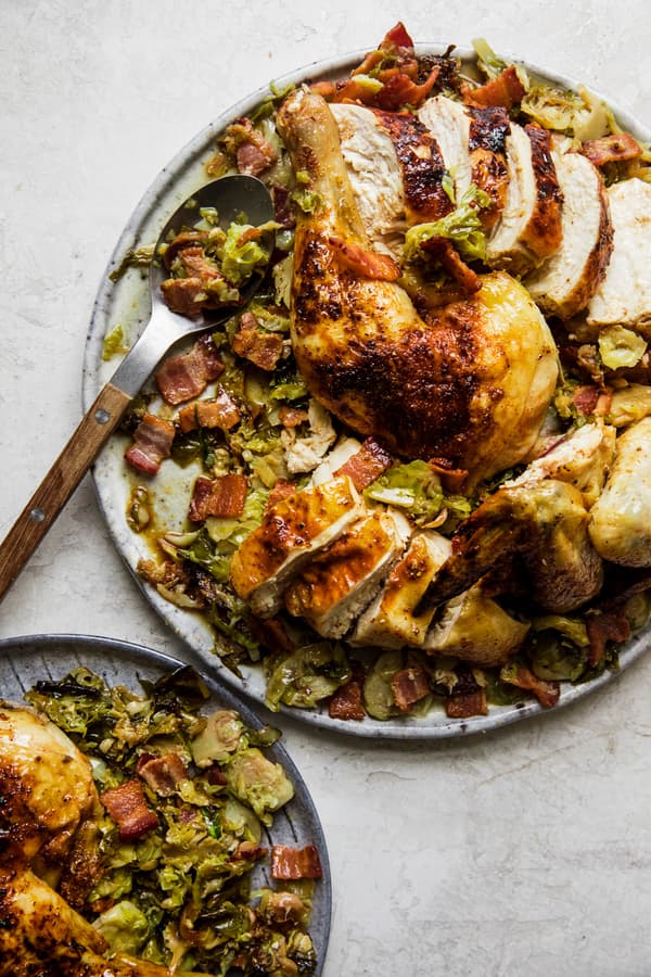 spatchcocked roast chicken on top of shredded Brussels sprouts on a serving platter