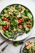 Spinach Orzo Salad With Feta, Tomatoes and a Basil Dressing in a serving bowl