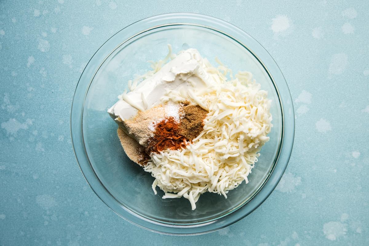 cream cheese, shredded cheese, spices in a bowl for stuffed peppers