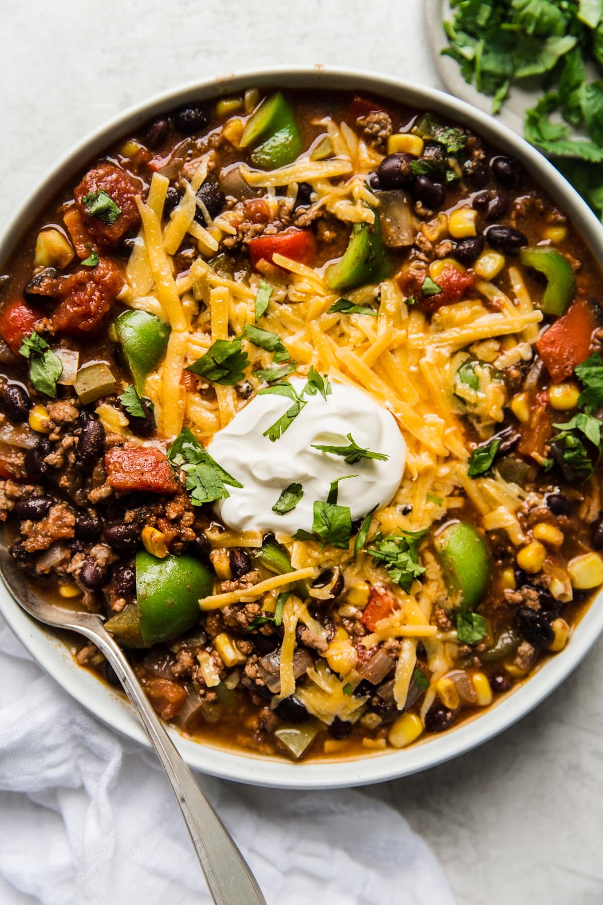 homemade taco soup recipe in a bowl with cheese and sour cream