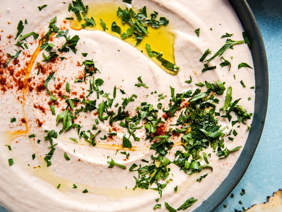 homemade White Bean Hummus in a bowl with paprika, olive oil and parsley