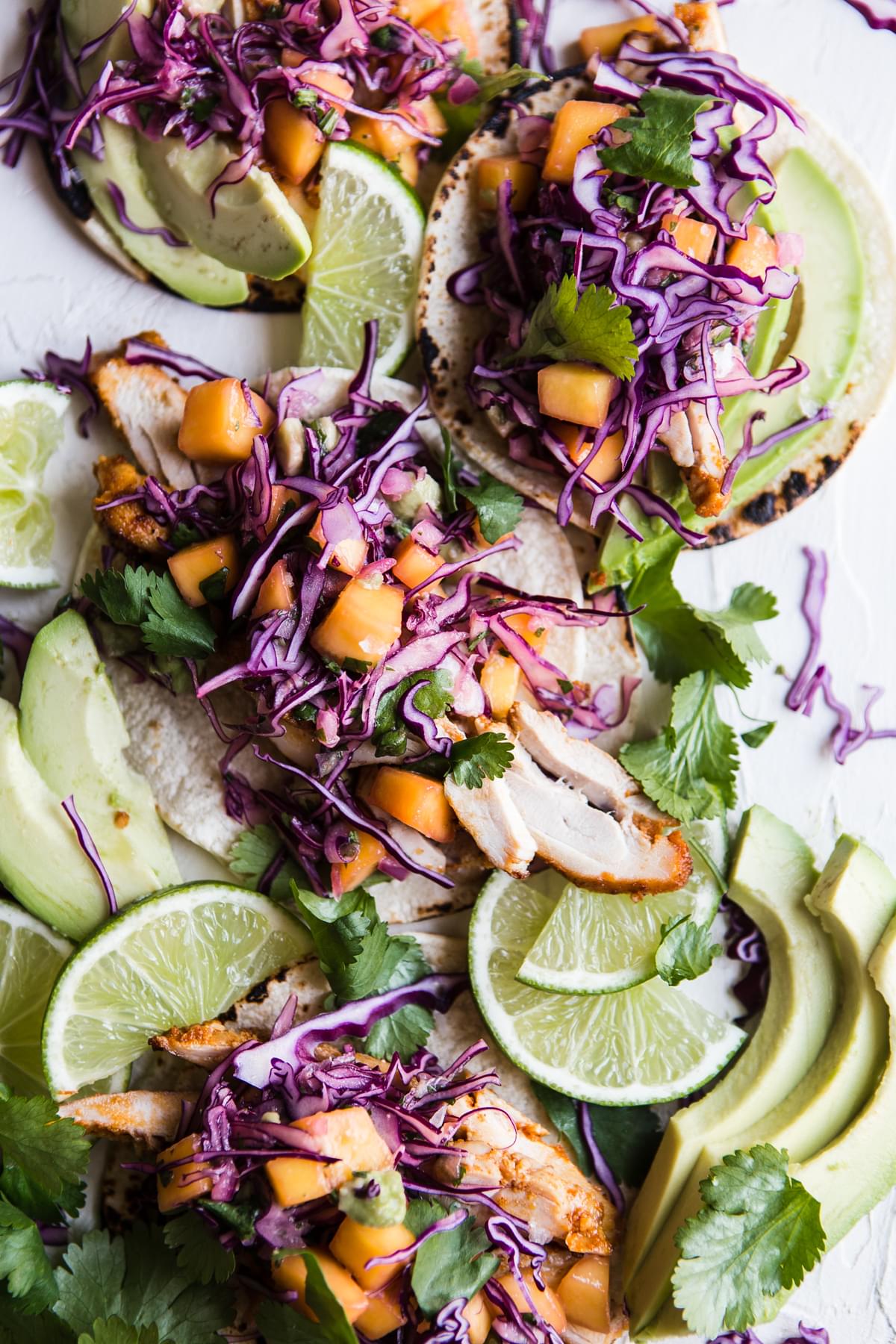 Chicken street tacos with mango slaw, avocado and lime