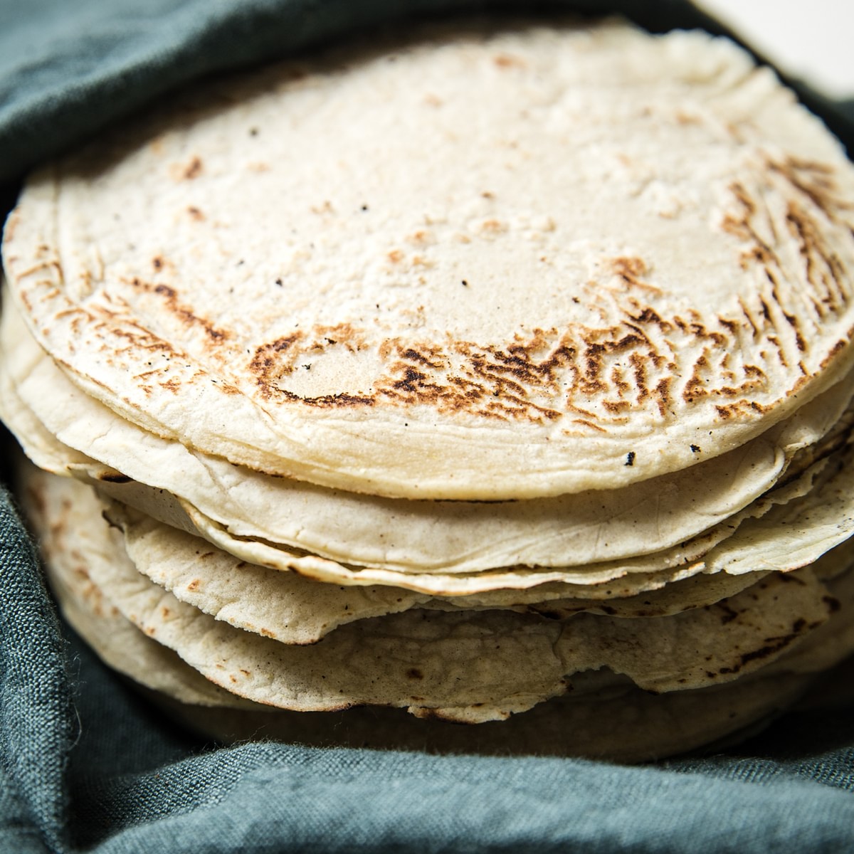Homemade corn tortillas wrapped in a towel