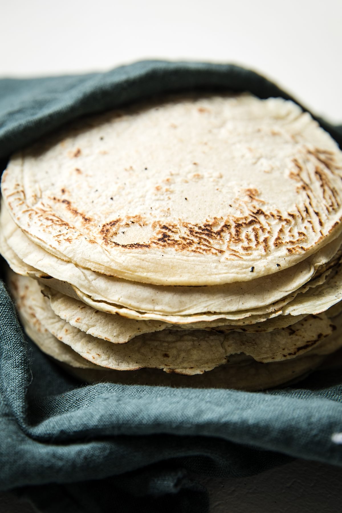 Homemade corn tortillas wrapped in a towel