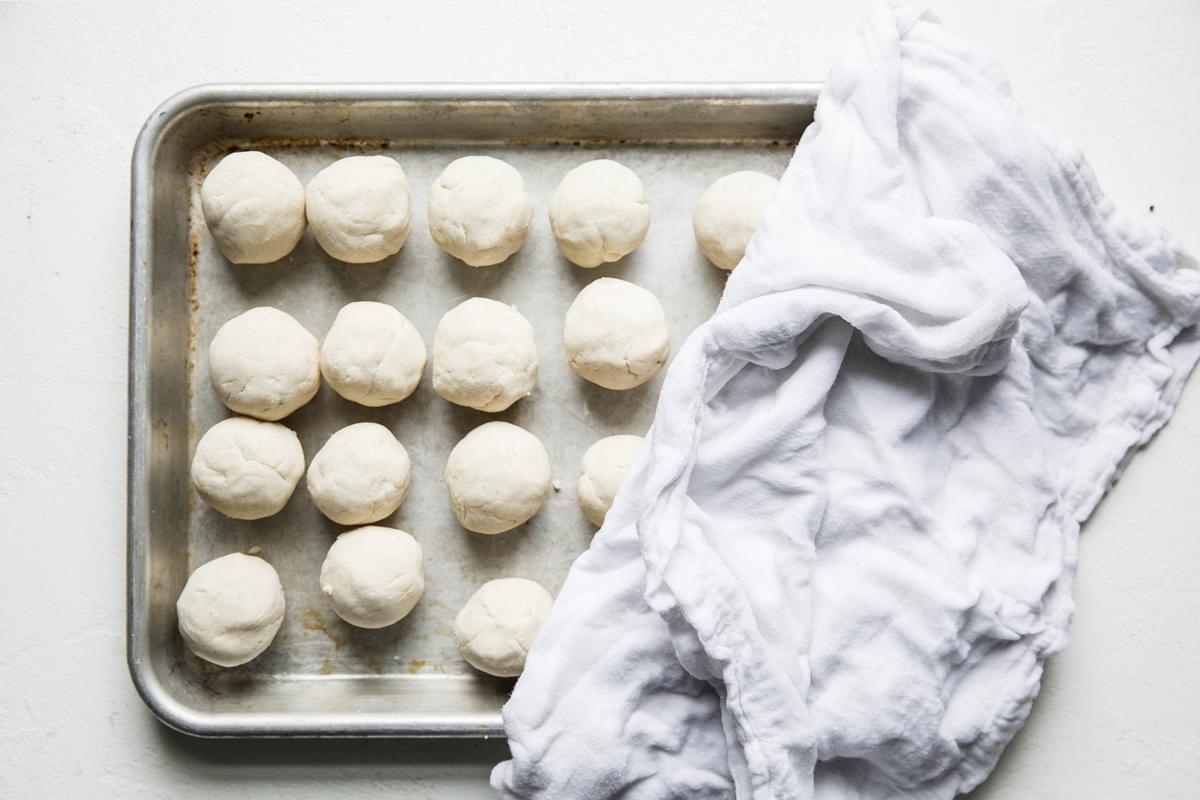dough rolled in balls on a baking sheet for corn tortillas