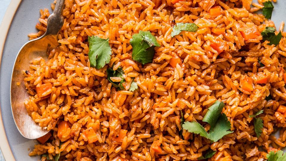 large plate of restaurant style Mexican rice on a large plate with a large spoon.