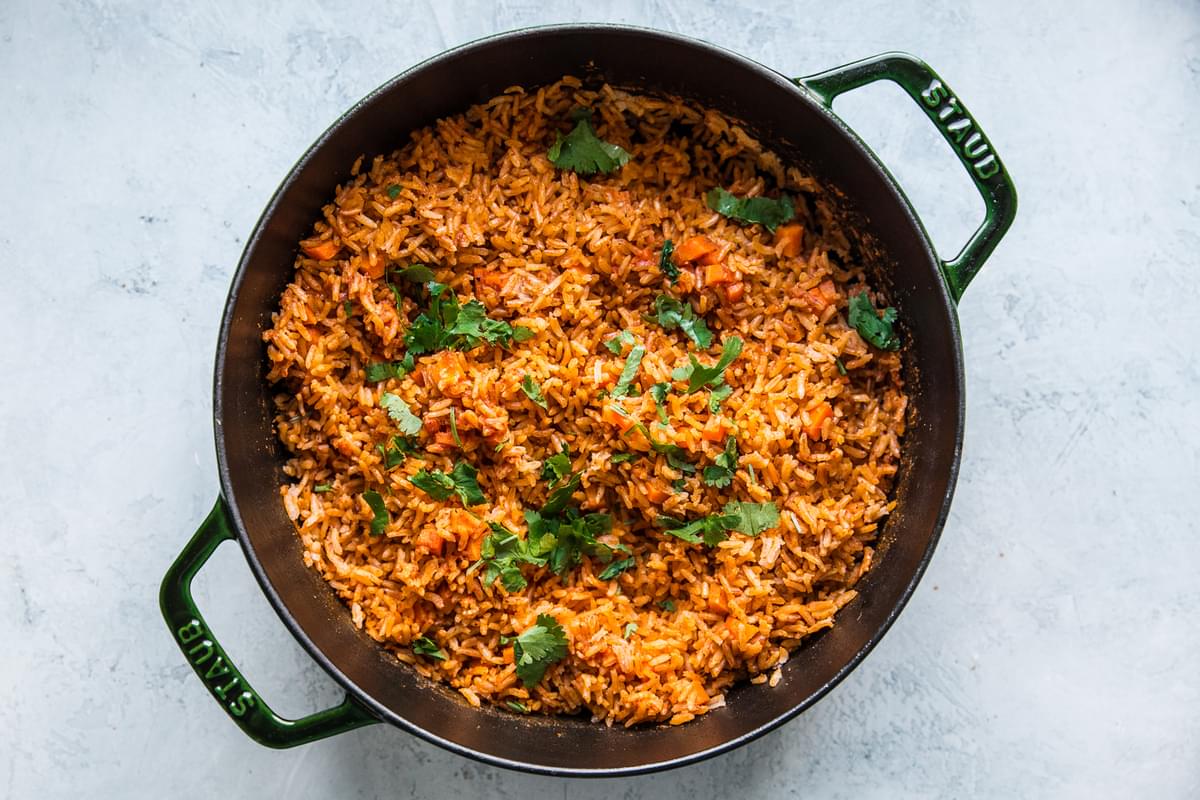 Restaurant style Mexican rice shown in a large pot topped with fresh cilantro