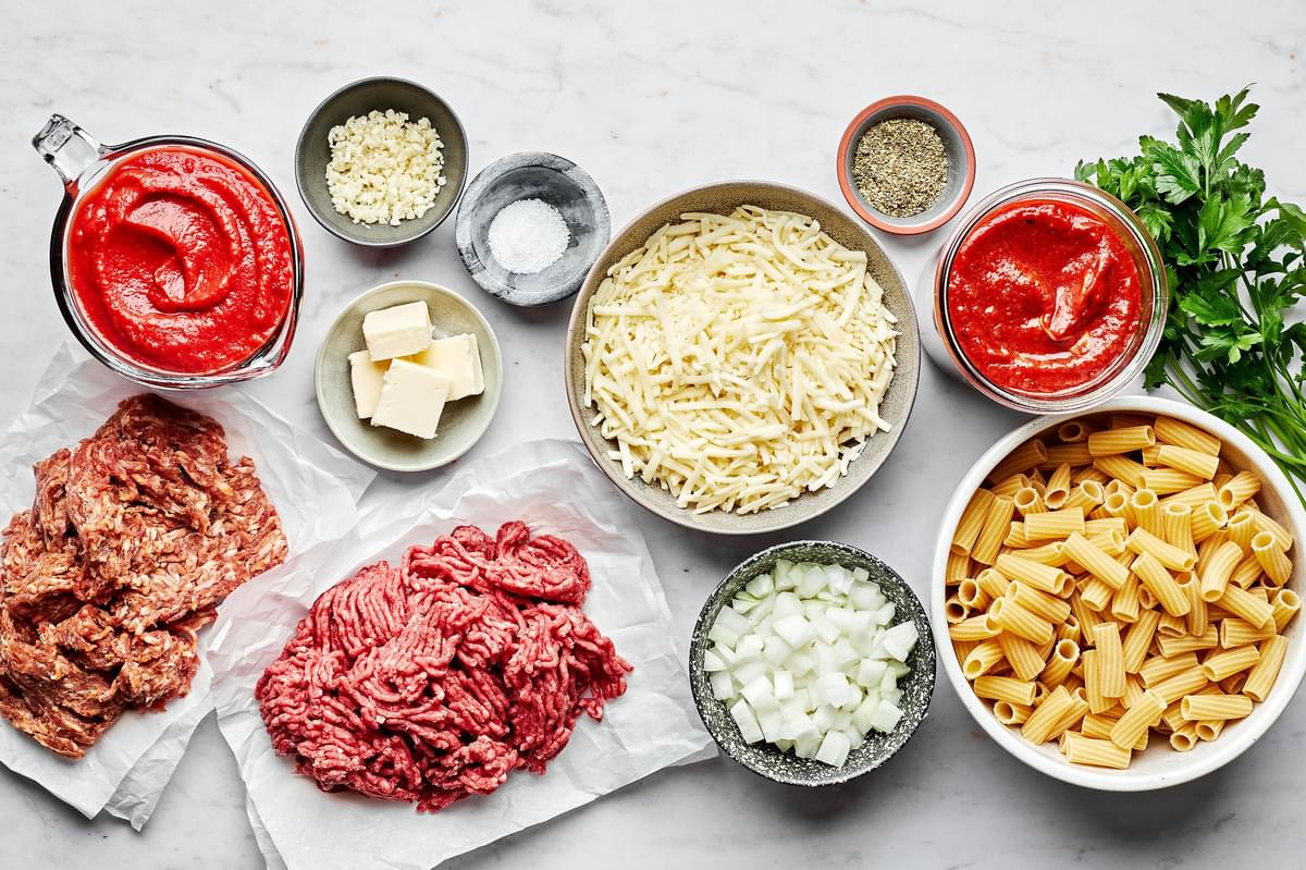 rigatoni, italian sausage, ground beef, onion, marinara, tomatoes, spices, butter and mozzarella in bowls