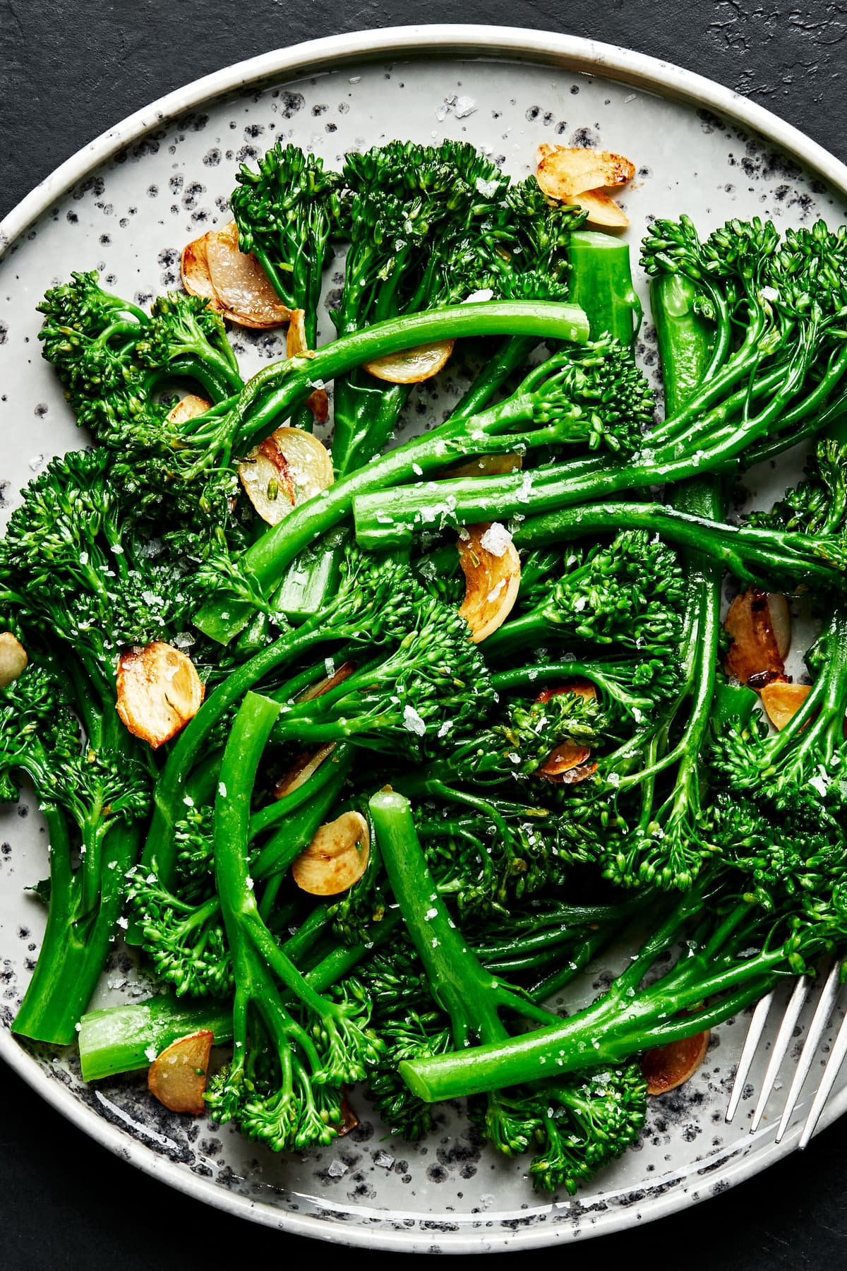 a plate of homemade broccolini cooked in olive oil and butter with salt and garlic and sprinkled with flaky salt