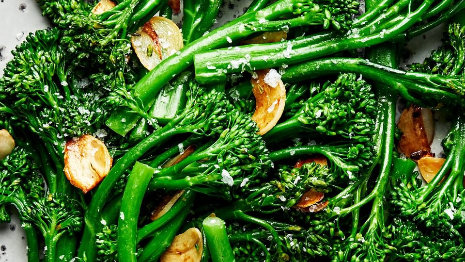 a plate of homemade broccolini cooked in olive oil and butter with salt and garlic and sprinkled with flaky salt