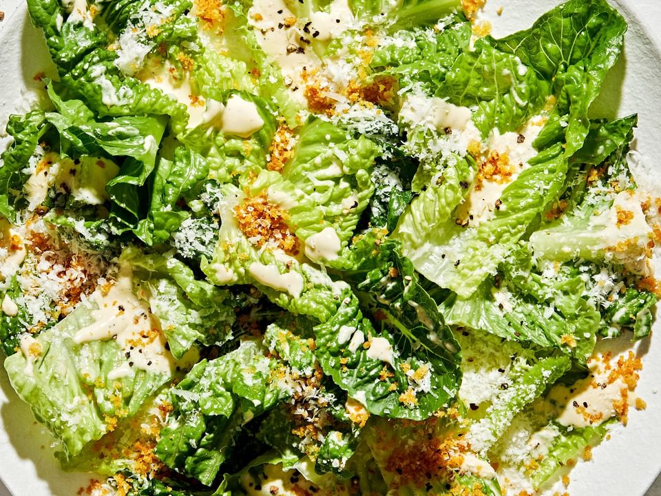 Caesar salad on a plate with homemade caesar dressing, toasted panko breadcrumbs and finely grated Parmesan cheese