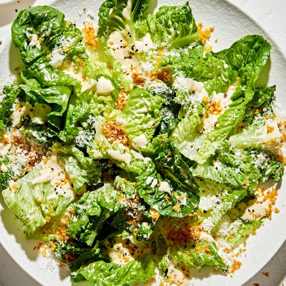 Caesar salad on a plate with homemade caesar dressing, toasted panko breadcrumbs and finely grated Parmesan cheese