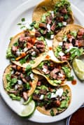 homemade carne asada tacos with onion, lime, and cilantro