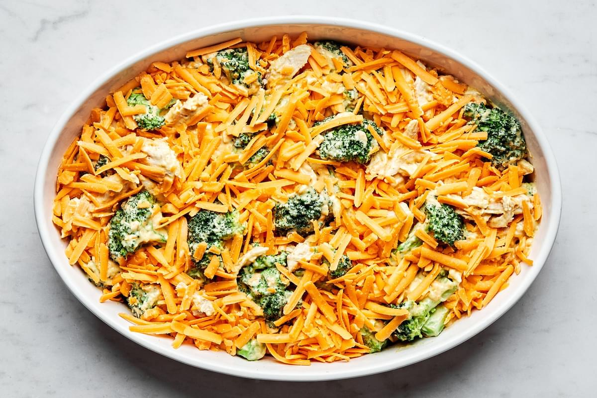 chicken divan in a casserole dish topped with shredded cheese