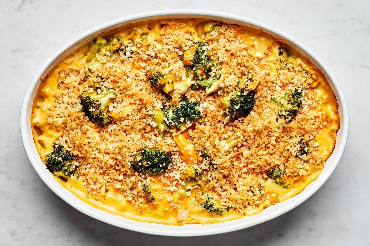chicken divan in a casserole dish with a serving spoon made with chicken, broccoli, cheese and topped with panko