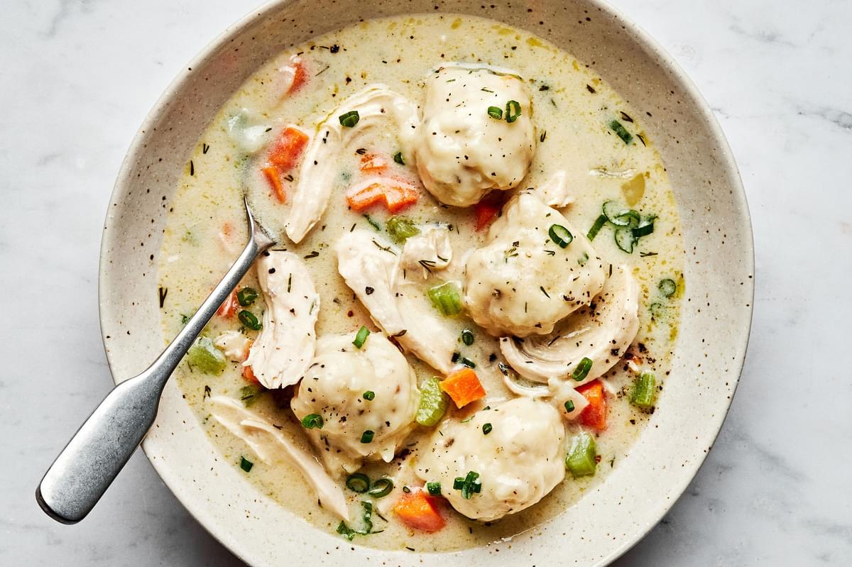 a bowl of homemade chicken and dumplings made with chicken, veggies, dill, spices, buttermilk and whole milk