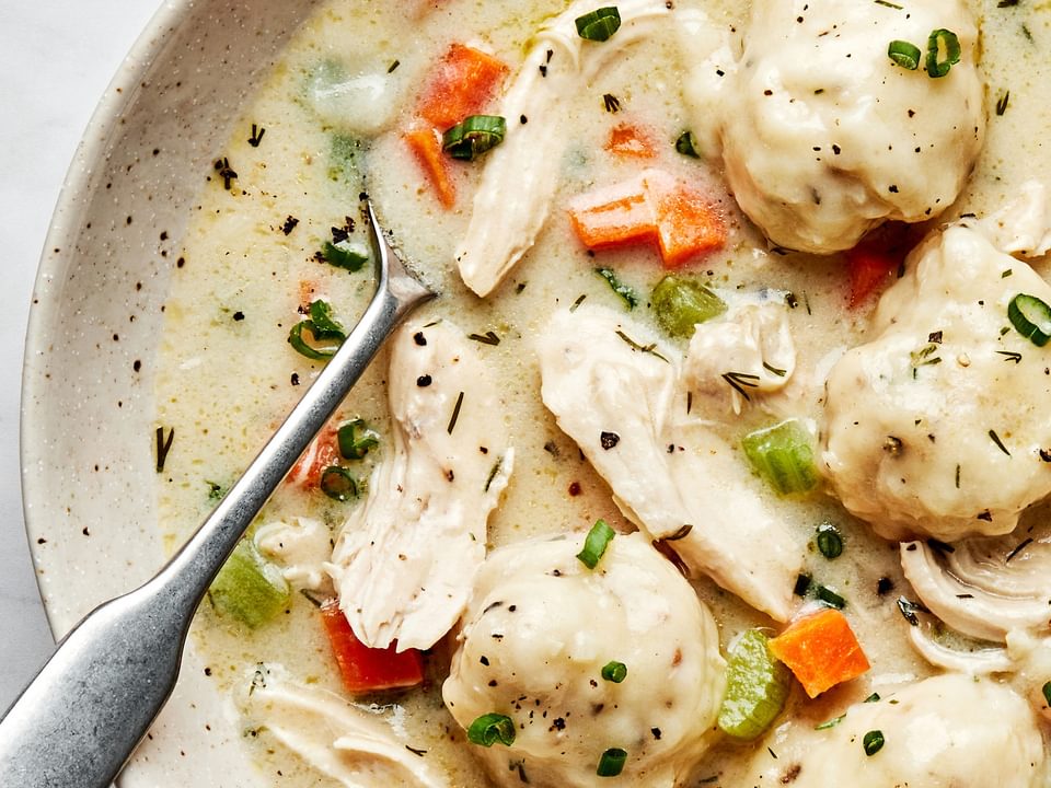 a bowl of homemade chicken and dumplings made with chicken, veggies, dill, spices, buttermilk and whole milk