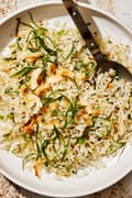 a bowl of homemade coconut fried rice made with coconut rice, green onions, ginger, coconut oil and sweetened coconut flakes