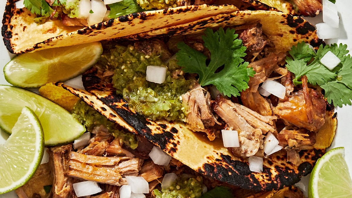crispy carnitas tacos in warmed corn tortillas topped with onion, cilantro and salsa verde served with lime wedges