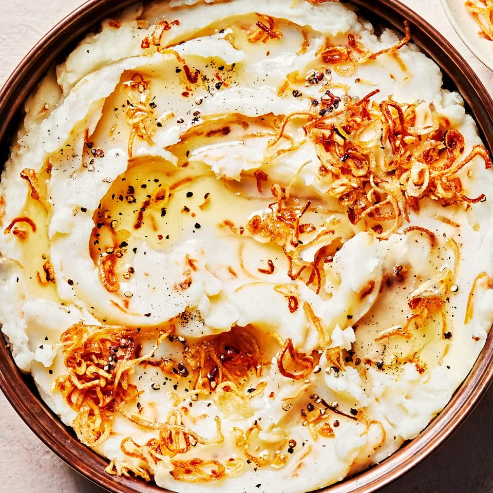 a bowl of homemade crispy shallot mashed potatoes made with butter, milk, garlic powder and salt