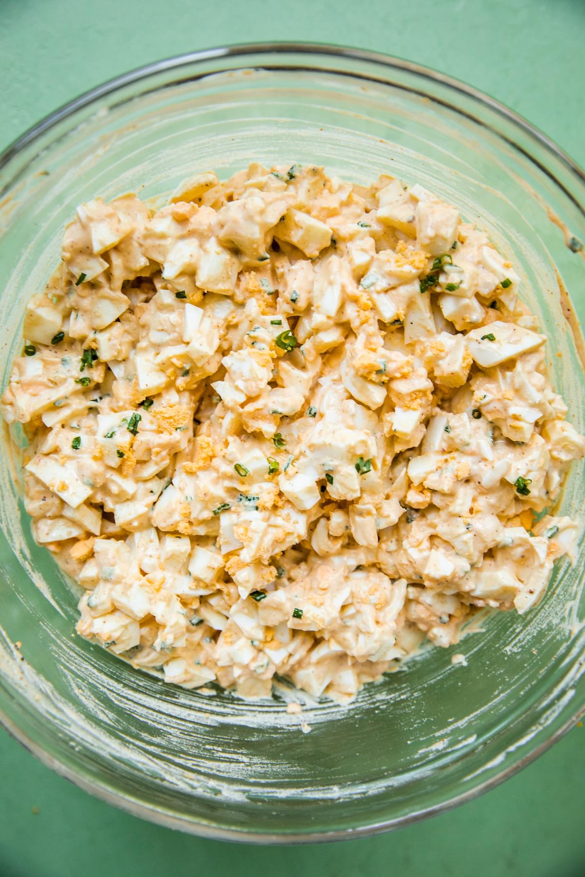 homemade egg salad in a glass bowl made with eggs, mayo, dijon, chives, apple cider vinegar and spices