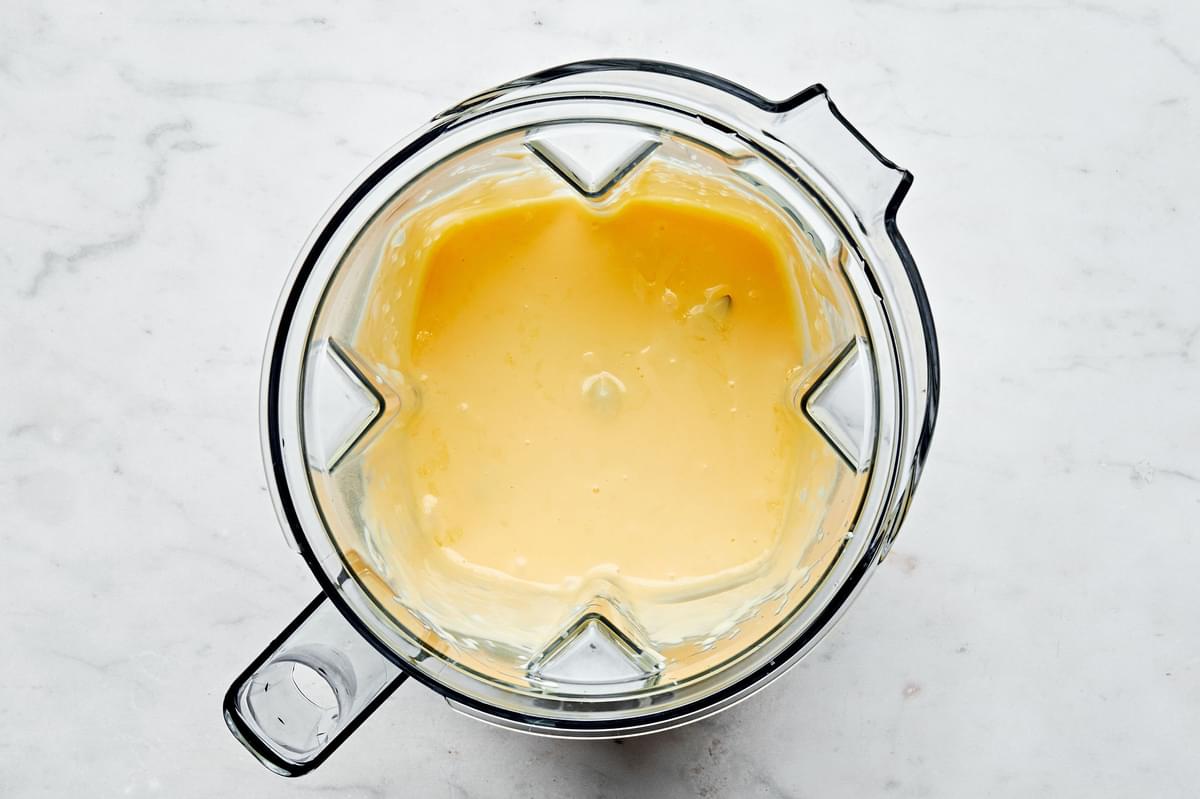 room temperature egg yolks, lemon juice and butter being combined in a blender