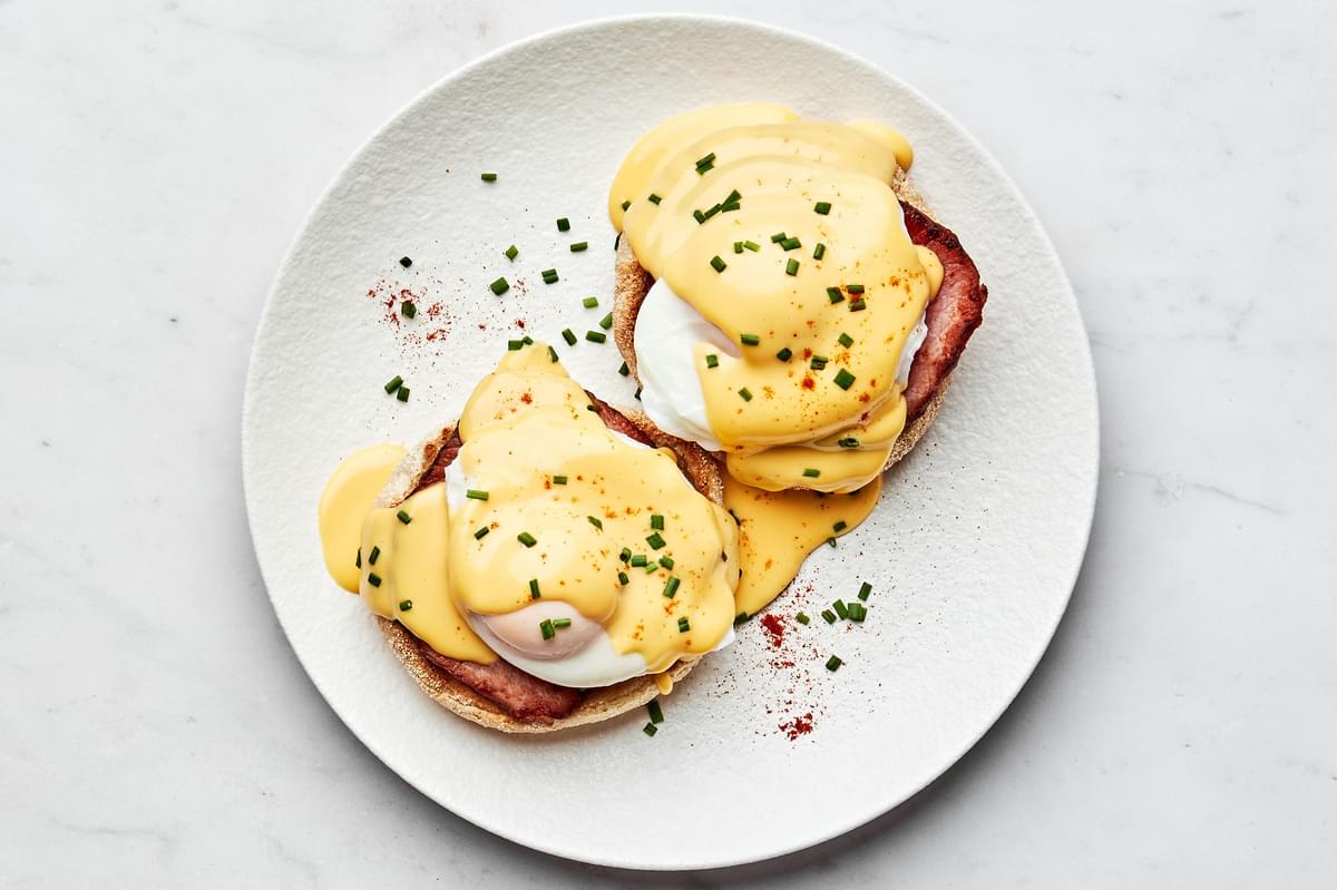homemade eggs Benedict made with Canadian bacon and homemade hollandaise sauce on a plate