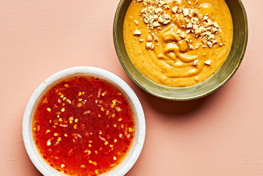 bowls of homemade peanut sauce and sweet chili sauce on the counter to use as dipping sauces for fresh spring rolls