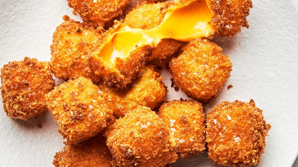 homemade fried cheese breaded with flour, salt, pepper, garlic and panko piled on a plate