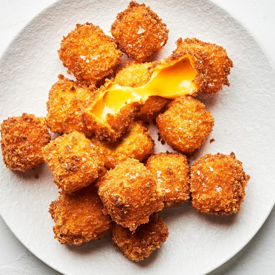 homemade fried cheese breaded with flour, salt, pepper, garlic and panko piled on a plate