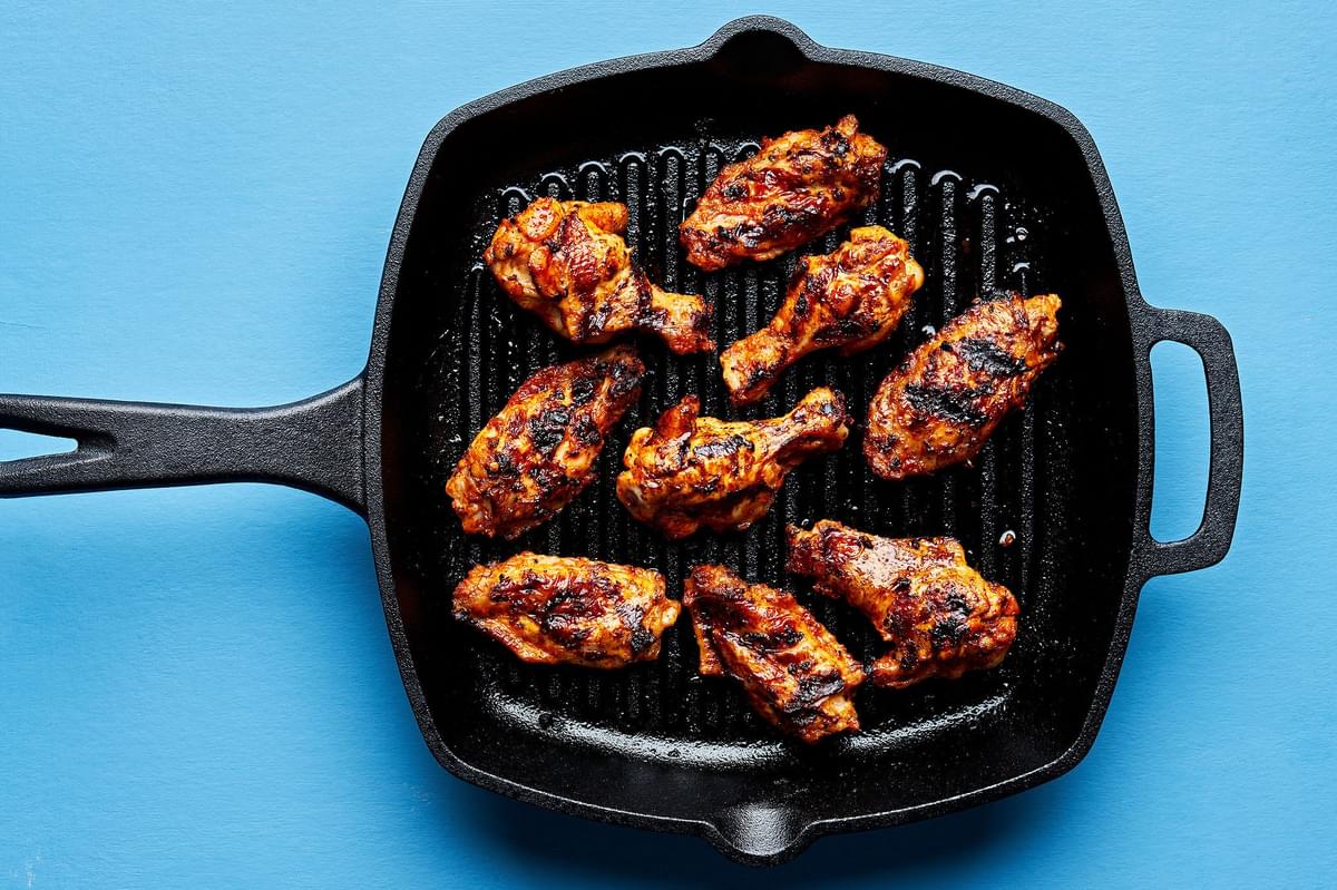 lemon pepper chicken wings being grilled on a grill pan