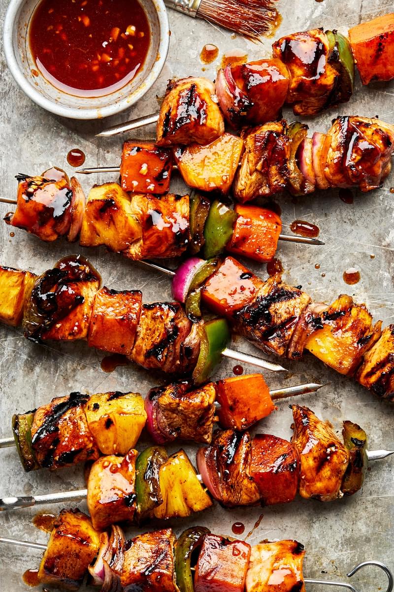 hawaiian chicken kabobs layered with sweet potatoes, bell pepper, pineapple & red onion brushed with a ginger-sesame marinade