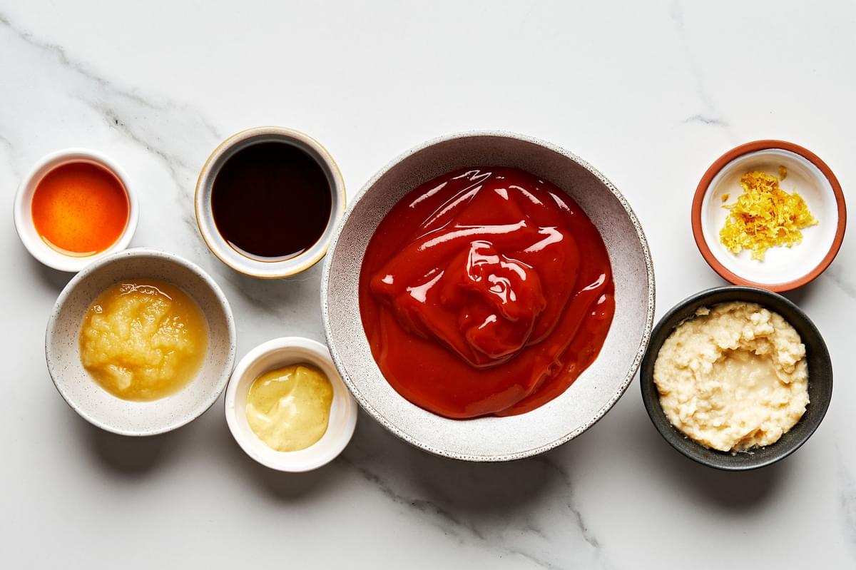 ketchup, horseradish, Worcestershire, Dijon, Tabasco, applesauce & lemon zest in bowls on the counter to make cocktail sauce