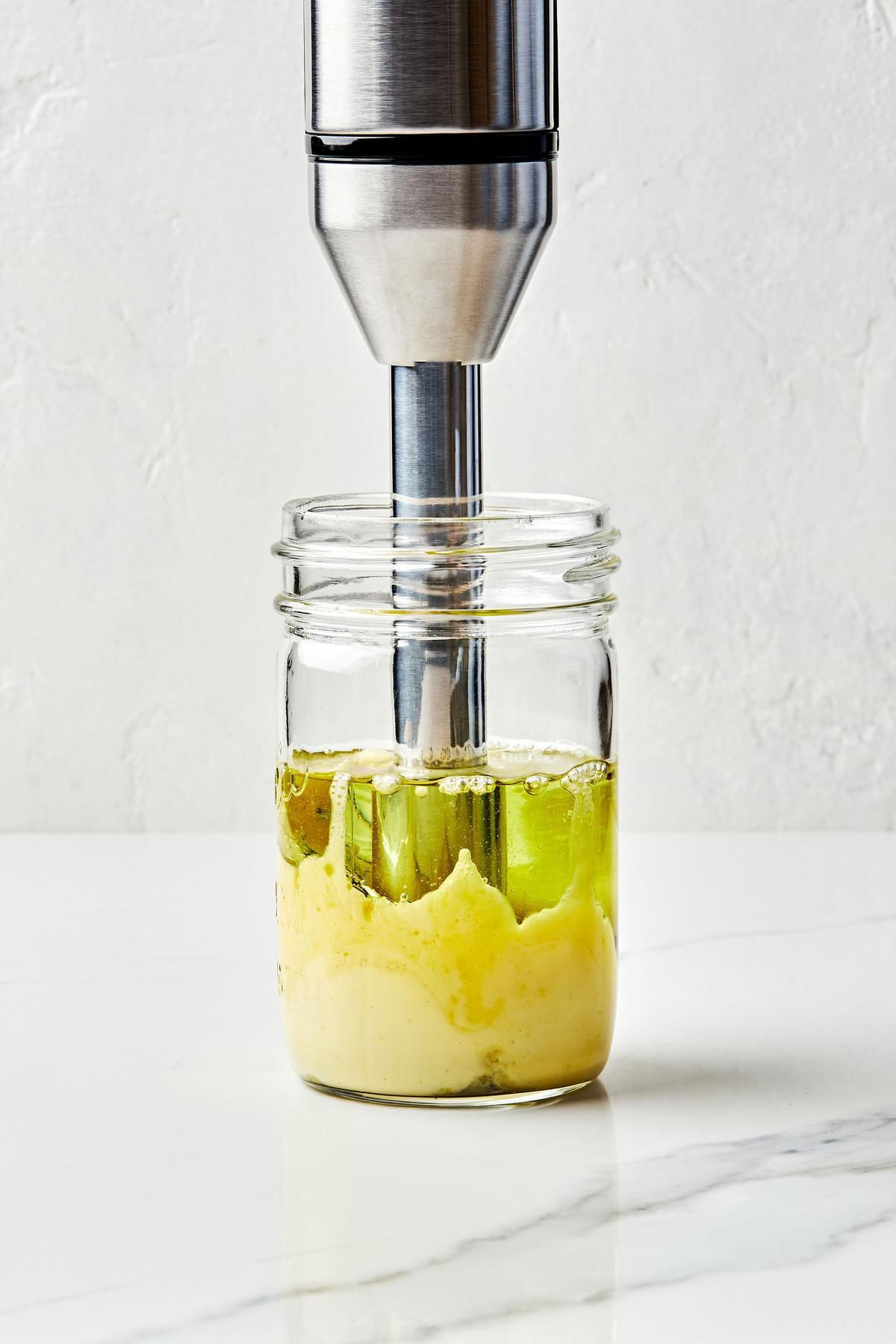egg, Garlic, Dijon mustard, salt, Lemon juice, lemon zest and grapeseed  oil in a jar being blended with an immersion blender