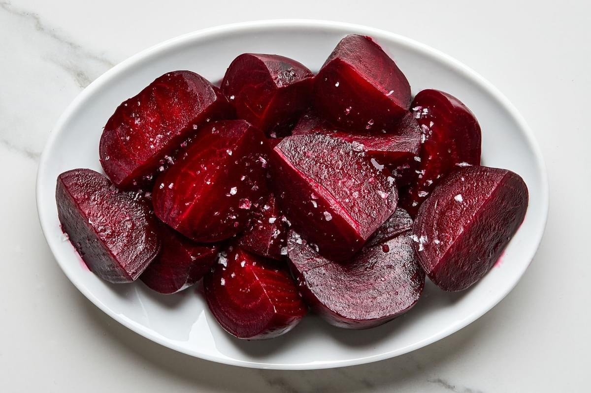 homemade roasted beets sliced, drizzled with olive oil and sprinkled with salt and pepper on a serving platter