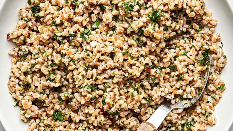 homemade farro in a serving bowl with a spoon