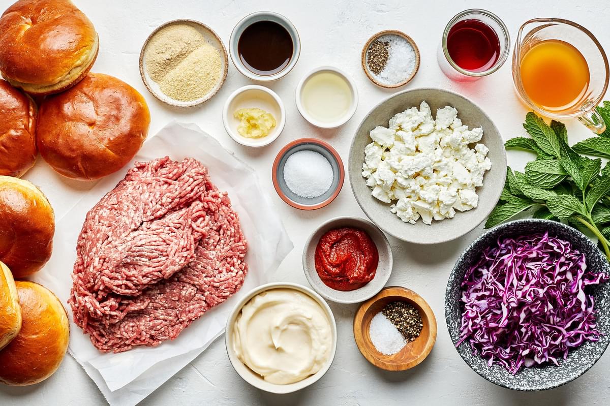 ground lamb, red cabbage, brioche buns, chèvre, mayo, mint, red wine vinegar and other ingredients in bowls on the counter