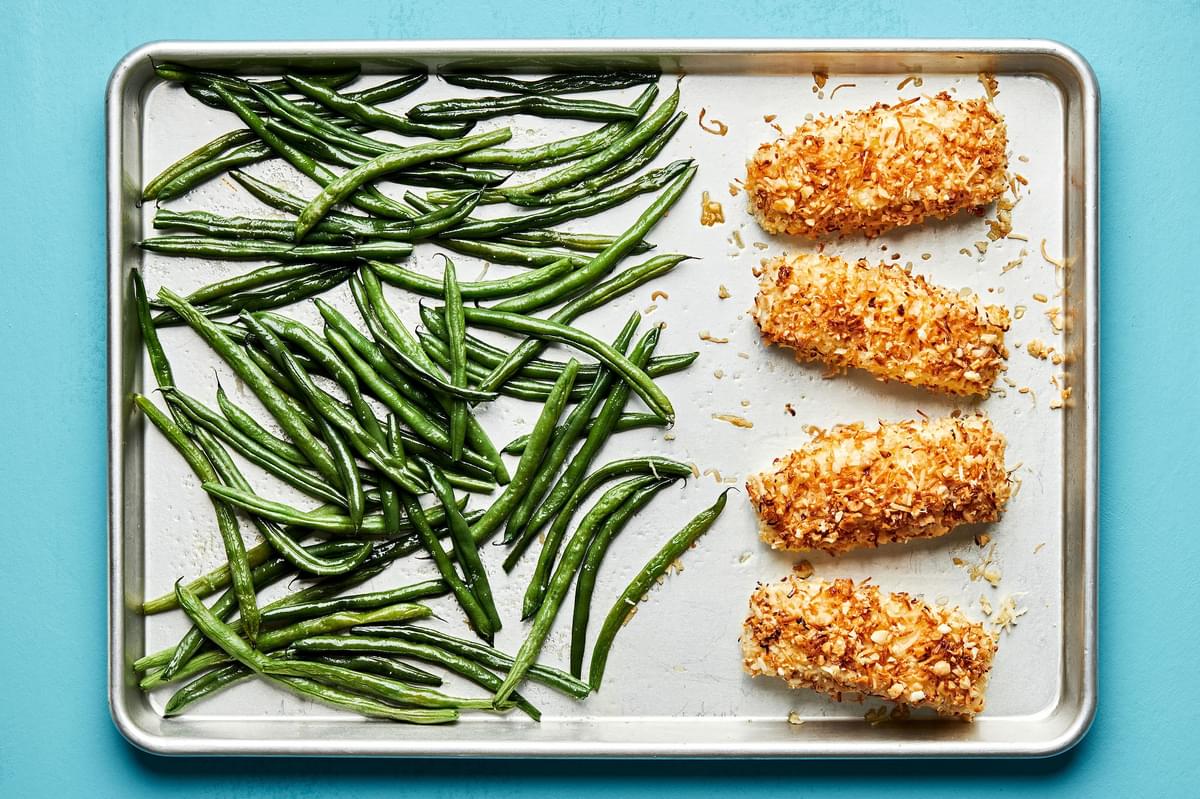 baked green beans and macadamia nut crusted fish on a baking sheet