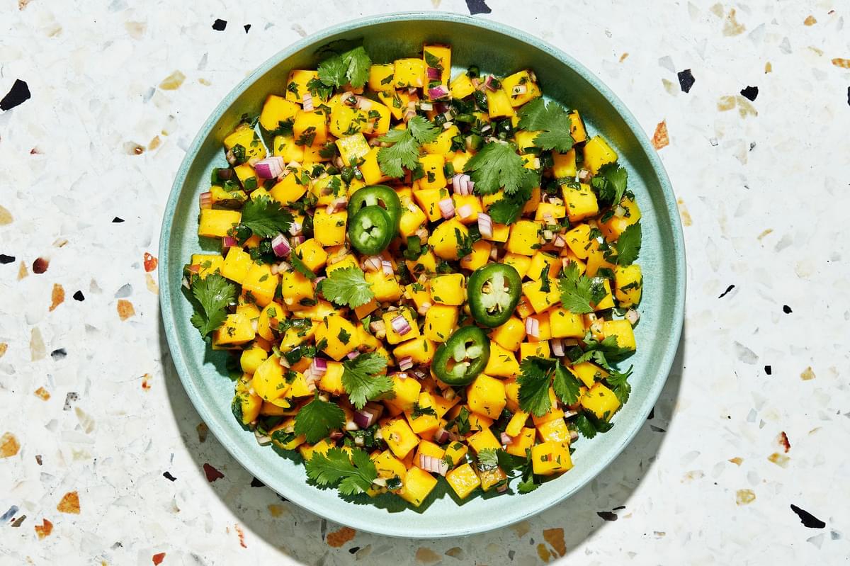 mango salsa in a serving bowl made with mango, red onion, cilantro, jalapeño, lime juice, salt, brown sugar and chili powder