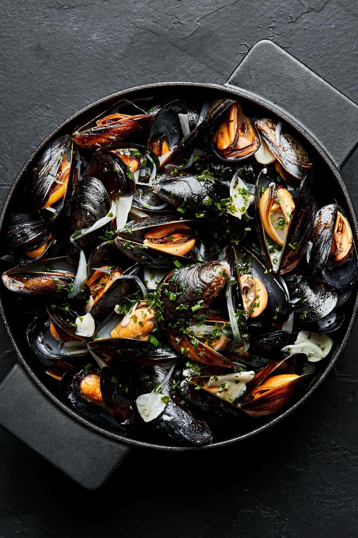 mussels in wine sauce in a soup pot made with butter, shallots, garlic, parsley and lemon juice