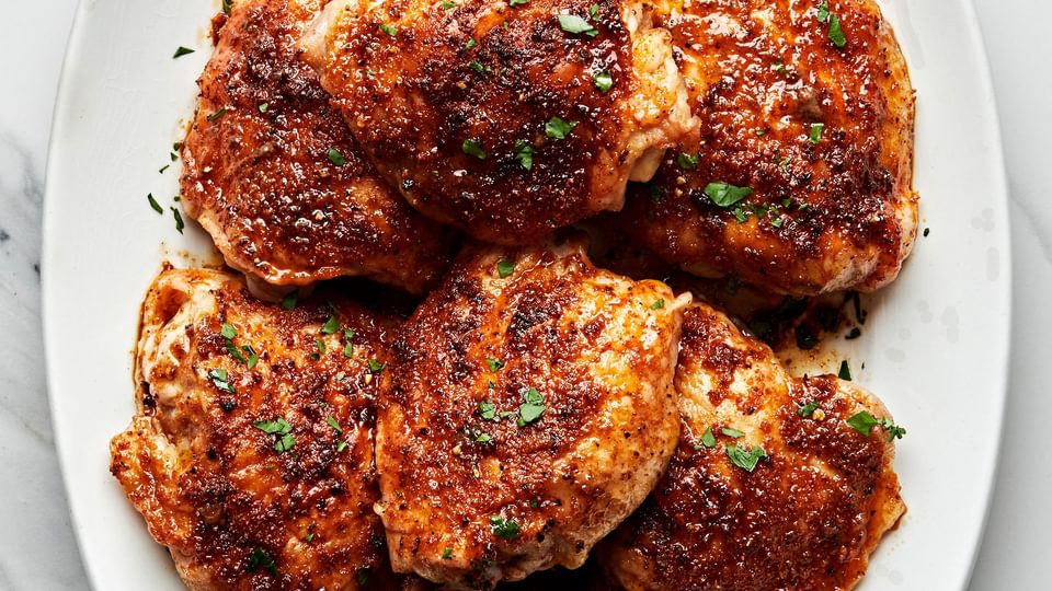 oven baked chicken thighs on a serving platter seasoned with olive oil, salt, garlic powder, onion powder, paprika, & pepper
