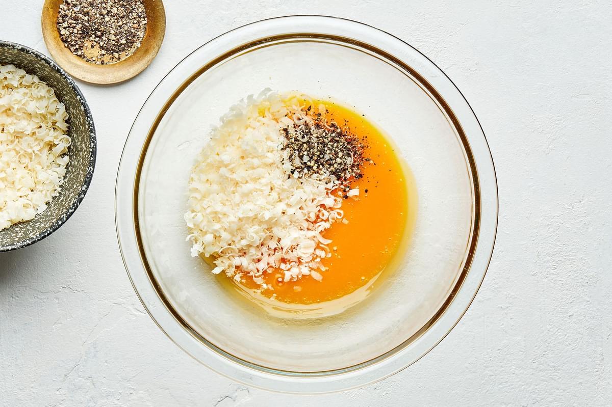 beaten egg yolks, Pecorino Romano and black pepper in a glass bowl
