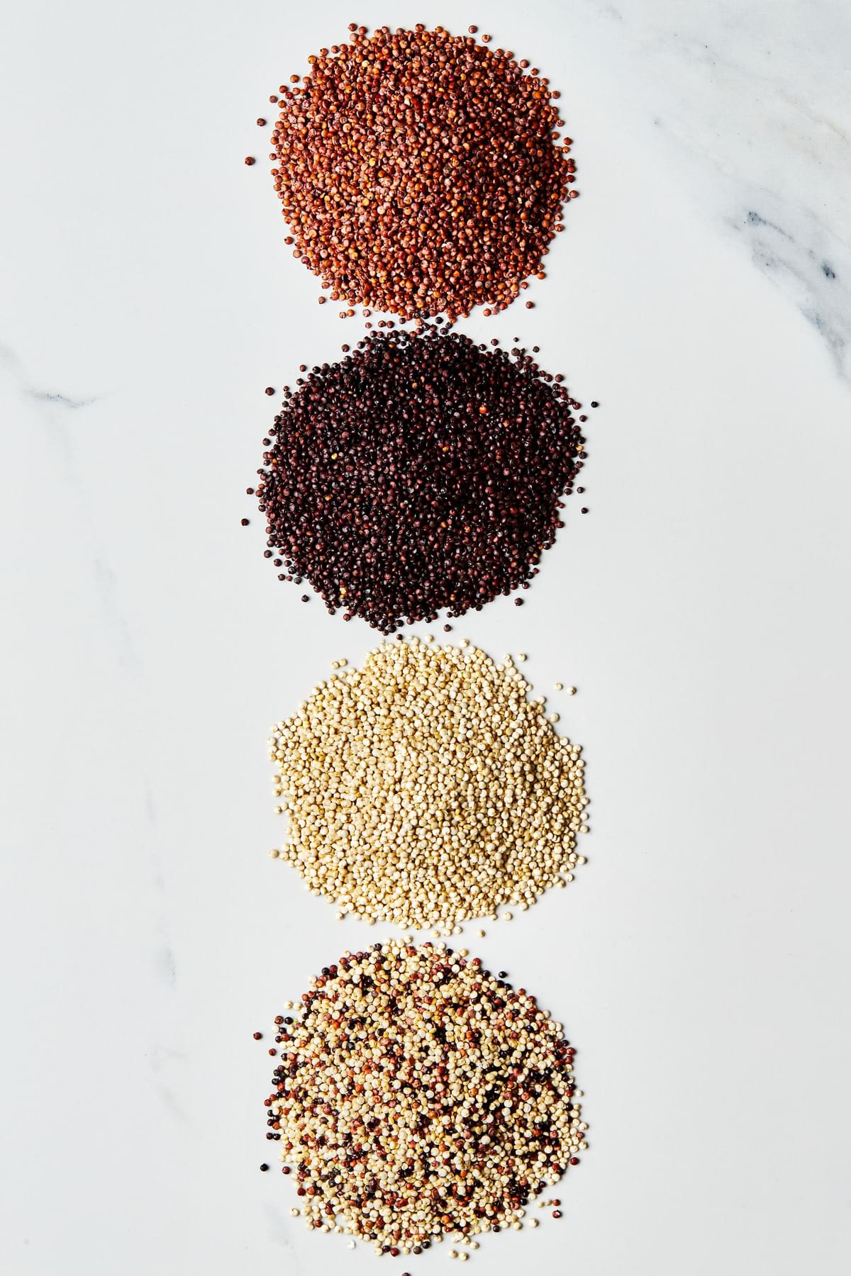 small piles of red, white, black and tri-color quinoa on the counter