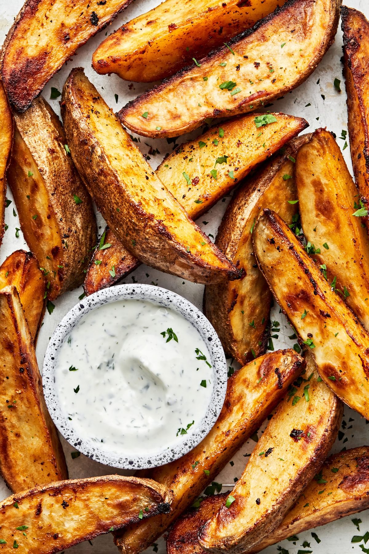 homemade Potato Wedges seasoned with brown sugar, salt, pepper, garlic powder and paprika served with a cup of Ranch dressing