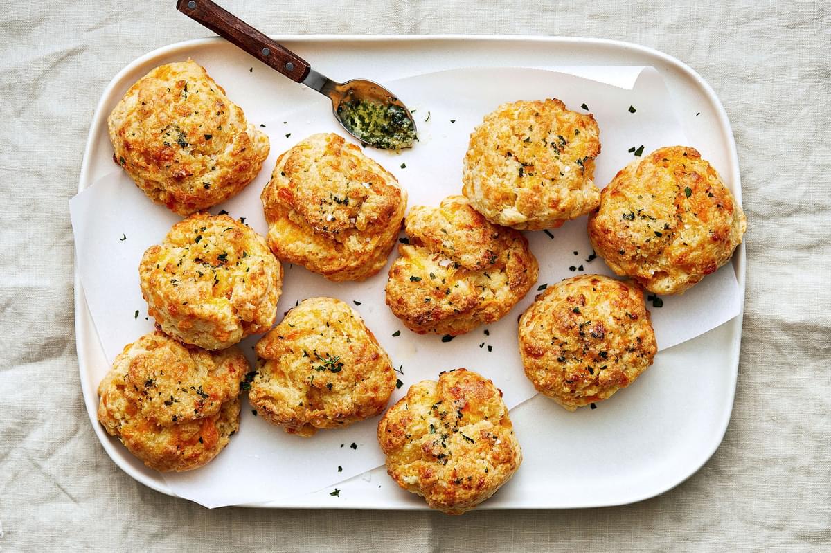 homemade red lobster cheddar bay biscuits topped with melted butter and spices (salt, onion, garlic and parsley) on a plate